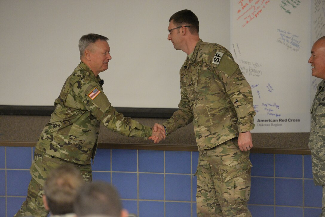 U.S. Army Gen. Frank Grass, chief of the National Guard Bureau, left, shakes hands and congratulates Master Sgt. Luke Gardiner, of the 219th Security Forces Squadron, as Grass meets with members of the North Dakota Army and Air National Guard at a town Hall style briefing at the Raymond J. Bohn Armory, Bismarck, North Dakota, Dec. 12, 2015. (U.S. Air National Guard photo by Senior Master Sgt. David H Lipp/Released)