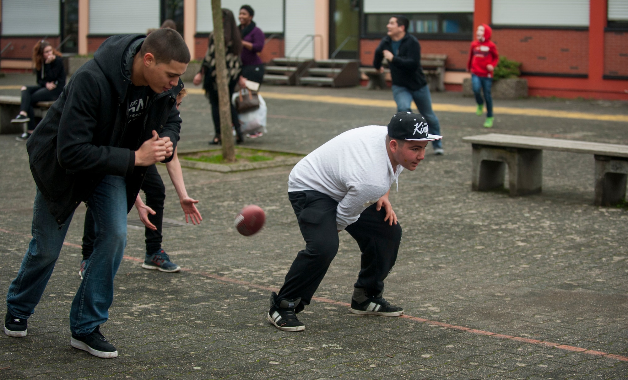Dogan, a St. Vinzenzhaus resident, right, hikes a football after a holiday party at the institution of child and youth services in Speicher, Germany, Dec. 13, 2015. Residents of St. Vinzenzhaus picked out their favorite presents from a stockpile and played with them afterwards. (U.S. Air Force photo by Airman 1st Class Timothy Kim/Released)