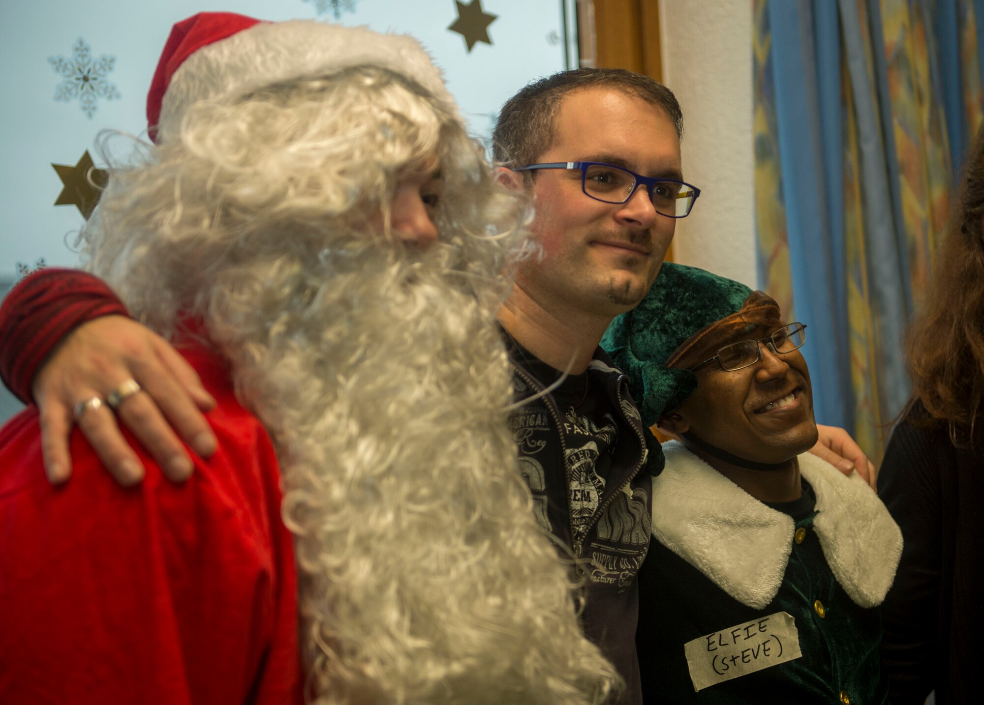 Dr. Alexander Knauff, University of Trier professor of social work and sciences and St. Vinzenzhaus caretaker, poses for a photo with Santa Claus and an elf during a holiday party at the institution of child and youth services in Speicher, Germany, Dec. 13, 2015. Volunteers from Spangdahlem Air Base’s First Four group selected two individuals to dress as Santa Claus and a Christmas elf to entertain the children. (U.S. Air Force photo by Airman 1st Class Timothy Kim/Released)
