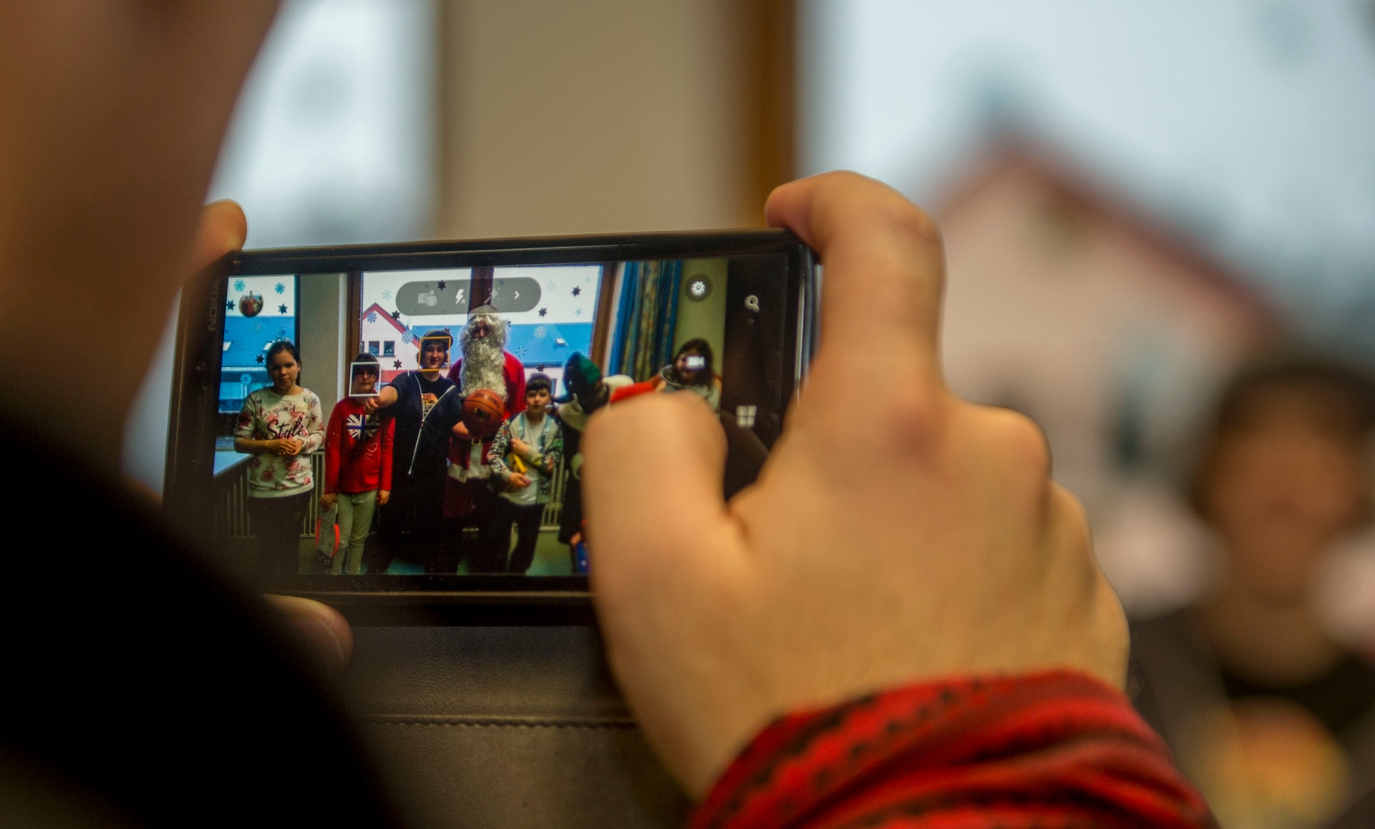 Dr. Alexander Knauff, University of Trier professor of social work and sciences and St. Vinzenzhaus caretaker, takes a photo of the institution’s residents with Santa Claus during a holiday party at the institution of child and youth services in Speicher, Germany, Dec. 13, 2015. Spangdahlem Air Base’s First Four group visited the institution to throw a holiday party. (U.S. Air Force photo by Airman 1st Class Timothy Kim/Released)