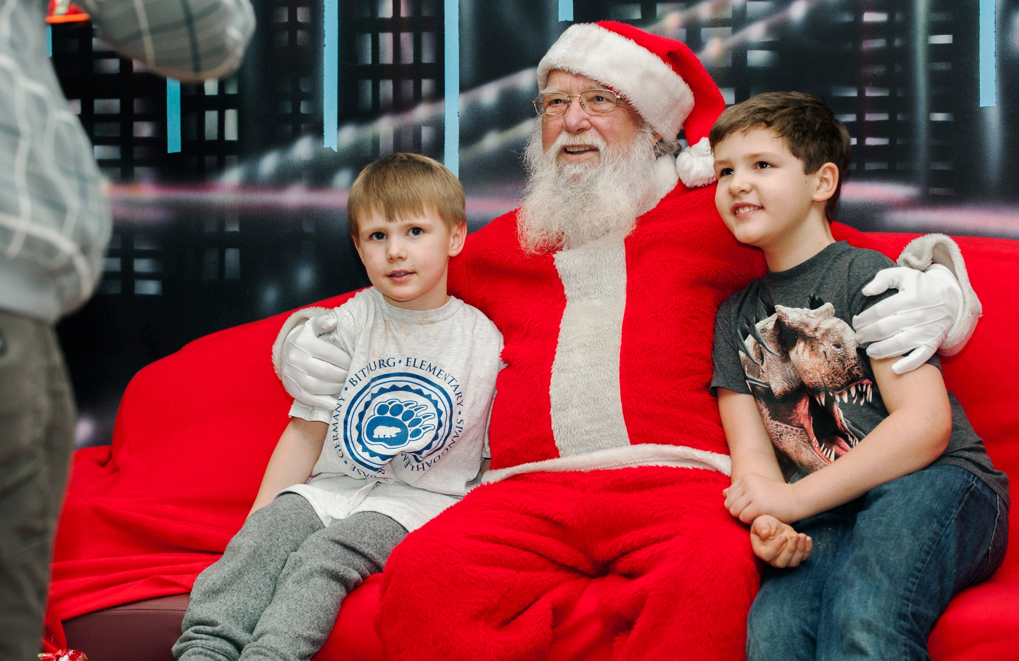 Santa Claus poses for a photo with two Spangdahlem community members during the annual tree-lighting ceremony at the Bowling Alley at Spangdahlem Air Base, Germany, Dec. 10, 2015. Spangdahlem community members and their children met Santa Claus, asked for presents and took photos. (U.S. Air Force photo by Airman 1st Class Timothy Kim/Released)