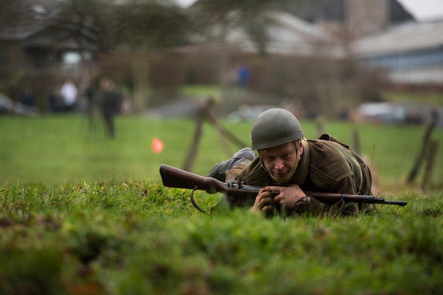 A WWII reenactment Allied Army soldier high crawls to avoid opposing gunfire during Operation Desperate Stand, Dec. 13, 2015, in Bertogne, Belgium. The Battle of the Bulge, which this reenactment was held to commemorate, took place in parts of Belgium, France, Luxembourg and Germany during the winter of 1944. (U.S. Air Force photo by Staff Sgt. Christopher Ruano/Released)