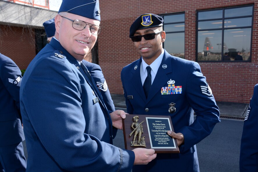 U.S. Air Force Staff Sgt. Joshua Graves, 145th Security Forces Squadron, receives the Outstanding Non-Commissioned Officer of the Quarter award for April-June 2015, from Col. Marshall C. Collins, commander, 145th Airlift Wing, during a ramp formation held at the North Carolina Air National Guard Base, Charlotte Douglas International Airport, Dec. 6, 2015. Graves has seven years of military service. (U.S. Air National Guard photo by Senior Airman Laura Montgomery, 145th Public Affairs/Released)