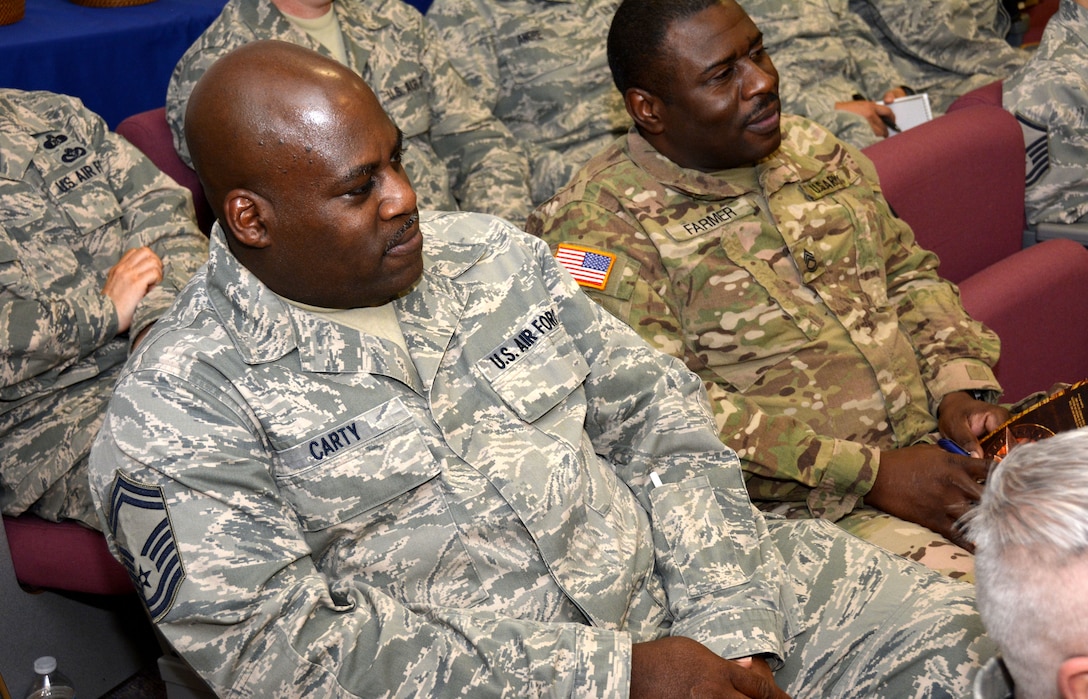 U.S. Air Force Senior Master Sgt. Gregory Carty and U.S. Army Sergeant First Class Kenneth Farmer, 881st Engineer Support Squadron, listen intently to instructors while attending a Four Lenses & Enhanced Human Capital course held at the North Carolina Air National Guard Base, Charlotte Douglas International Airport, Dec. 11, 2015. More than 100 Airmen and Soldiers from the North Carolina National Guard attended the day-long professional development training where attendees learned better ways to communicate, not only as supervisors but strengthen communication and personal interaction with coworkers, family and friends. (U.S. Air National Guard photo by Master Sgt. Patricia F. Moran /Released)