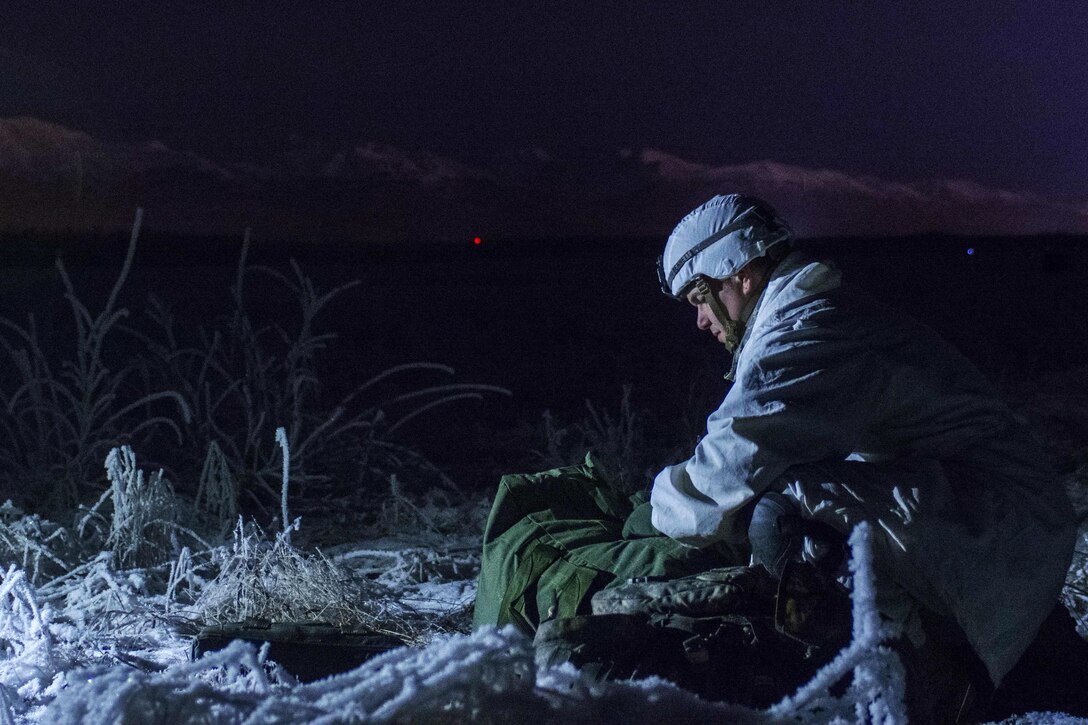 Army Staff Sgt. Timothy Bennett packs his parachute after a night airborne training jump on Joint Base Elmendorf-Richardson, Alaska, Dec. 8, 2015. Bennett is a cavalry scout with the 25th Infantry Division's Troop B, 1st Squadron, 40th Cavalry Regiment, 4th Infantry Brigade Combat Team. U.S. Army photo by Staff Sgt. Daniel Love