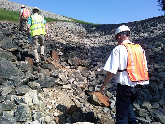 Risk cadre members observe newly placed riprap slope protection placed to prevent erosion on a steep slope at the Beach City Dam in Ohio for the Huntington District July 2012.