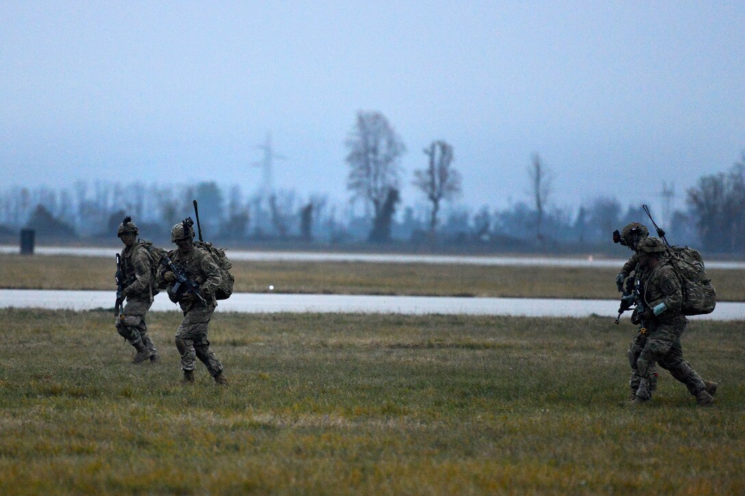 U.S. Army paratroopers move out for a follow-on mission after disembarking from aircraft during Exercise Rock Nemesis at Rivolto Air Base, Italy, Dec. 4, 2015. U.S. Army photo by Paolo Bovo