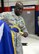 Tech. Sgt. Kevin Fairman, a member of the 149th Fighter Wing, puts away a two-star command flag after an all call, held Dec 10, in a maintenance hangar at Joint Base San Antonio-Lackland, Texas.