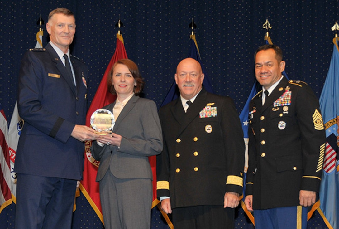 DLA Director Air Force Lt. Gen. Andy Busch presents a DLA Outstanding Personnel of the Year award to Natalya Radyk, Maritime Supplier Operations, at the 48th Annual DLA Employee Recognition Ceremony Dec. 10 at the McNamara Headquarters Complex in Ft. Belvoir, Va. Pictured with Busch and Radyk is Land and Maritime commander Navy Rear Adm. John King, and Army Command Sgt. Maj. Charles Tobin, DLA’s senior enlisted leader. 