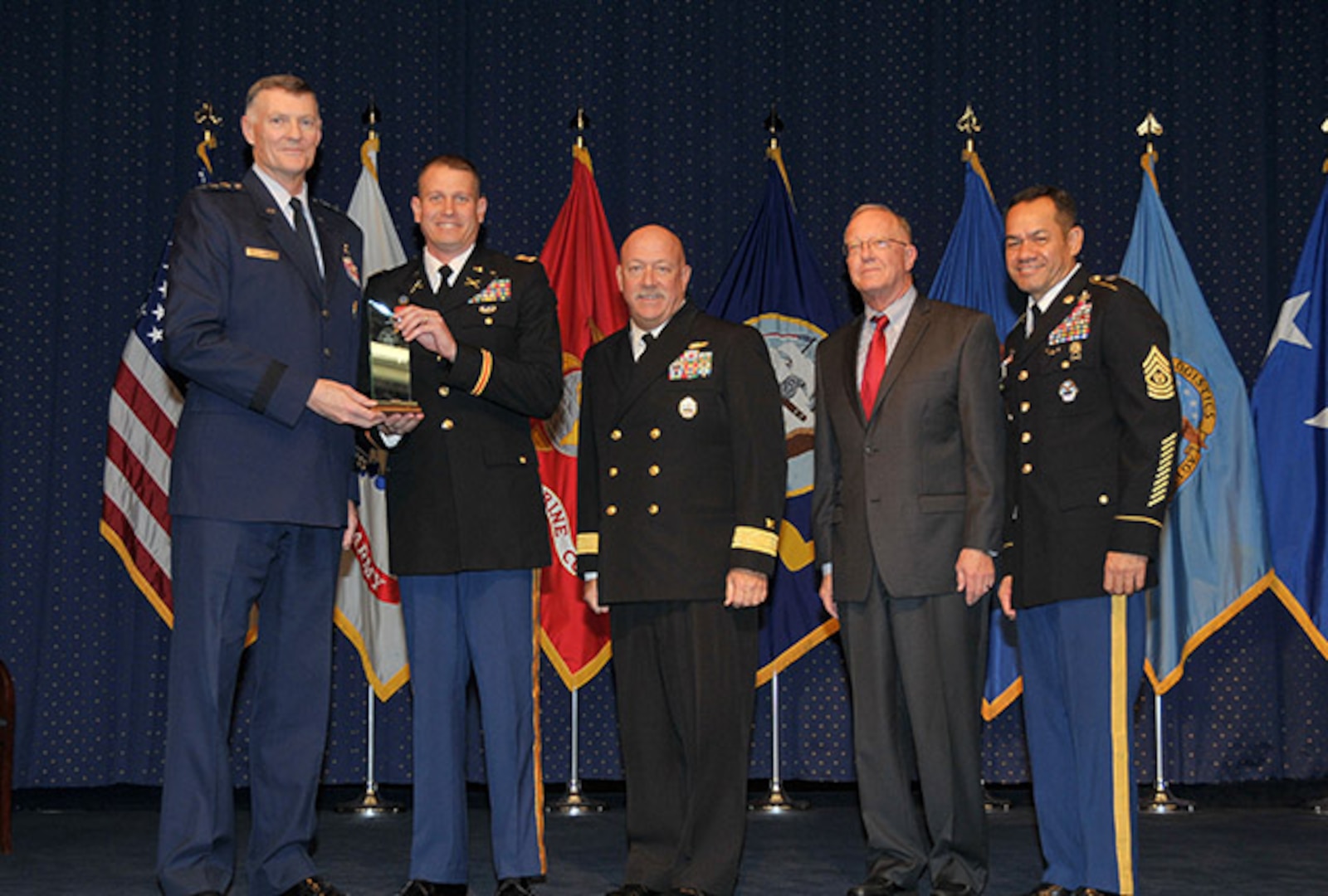DLA Director Air Force Lt. Gen. Andy Busch presents the DLA Joint Reserve Forces Junior Officer of the Year award to Army Capt. Vince Barber at the 48th Annual DLA Employee Recognition Ceremony Dec. 10 at the McNamara Headquarters Complex in Ft. Belvoir, Va. Pictured with Busch and Barber is Land and Maritime commander Navy Rear Adm. John King, Robert A. McCullough, DLA Deputy Director J9, Joint Reserve Force, and Army Command Sgt. Maj. Charles Tobin, DLA’s senior enlisted leader.