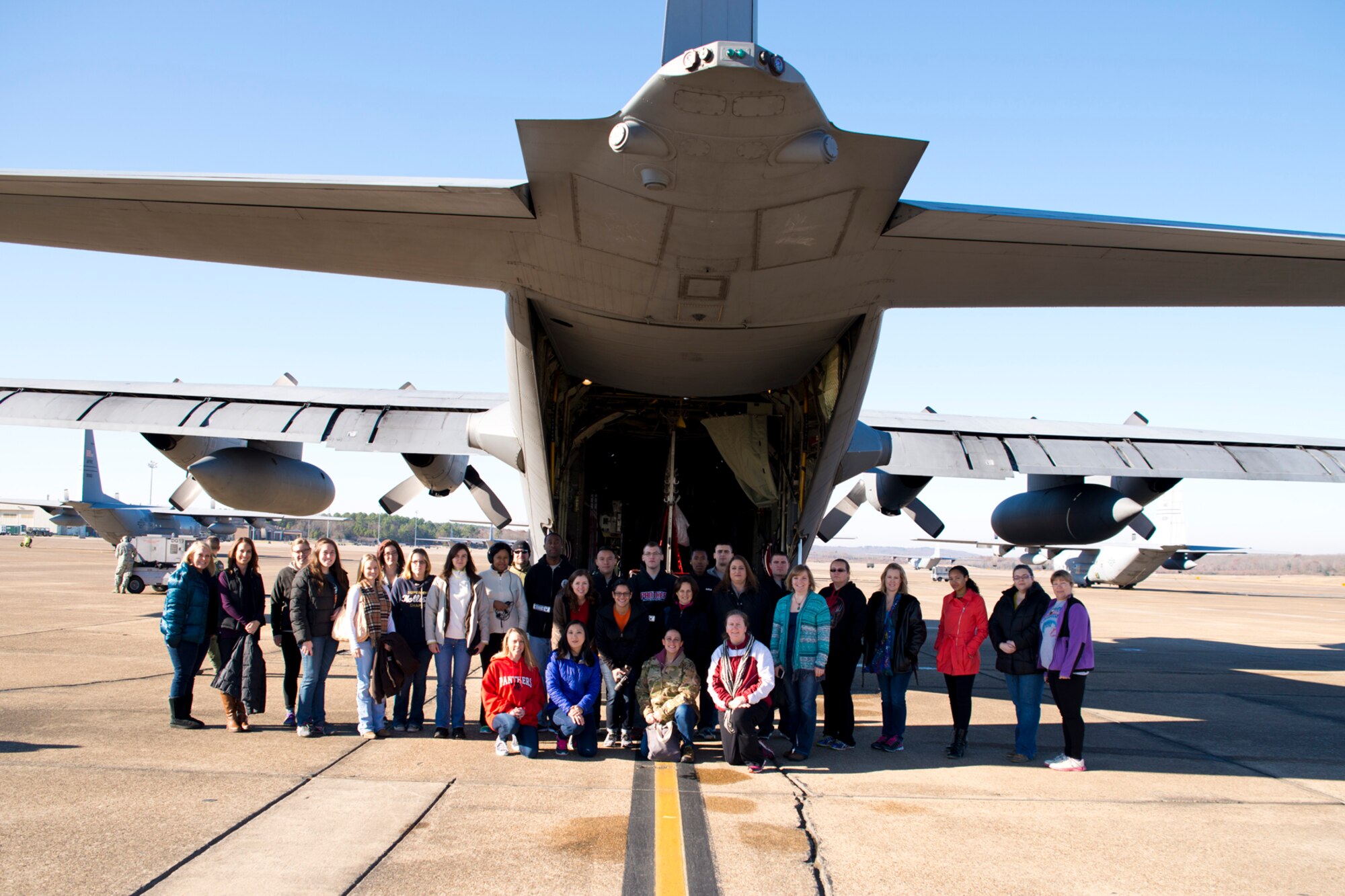Spouses of the 913th Airlift Group pose behind a C-130H Hercules before boarding an incentive flight at Little Rock Air Force Base, Dec. 5, 2015. Hosted by the 913th AG, the flight was used as a teaching tool to show spouses what their loved ones do on a daily basis to keep the country safe. (U.S. Air Force photo by Capt. Casey Staheli/Released)