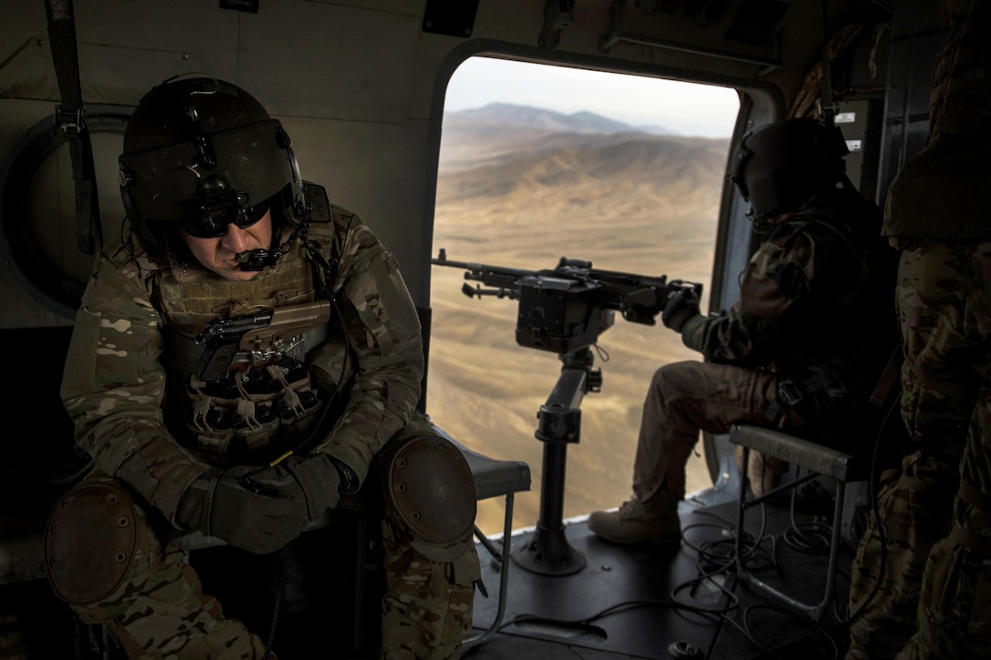 U.S. Air Force Tech. Sgt. Danny Bogan, left, rides with an Afghan air force aerial gunner aboard an Afghan air force Mi-17 helicopter during training near Kabul, Afghanistan, Dec. 7, 2015. Bogan's mission is to train, advise, and assist our Afghan partners to develop a professional, capable and sustainable air force. Bogan is an aerial gunner assigned to the Train, Advise, Assist Command-Air. U.S. Air Force photo by Staff Sgt. Corey Hook