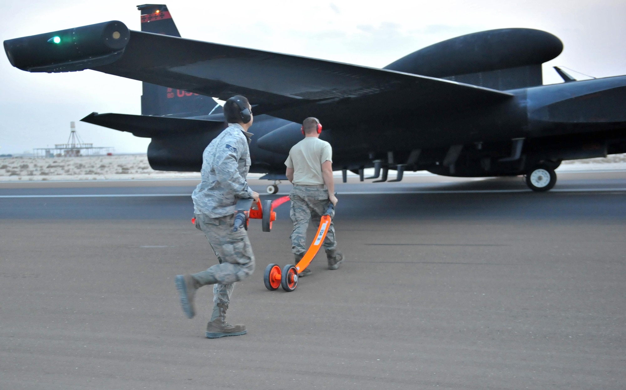 Dragon Aircraft Maintenance Unit Airmen rush to insert pogo sticks under the wings of a U-2 Dragon Lady aircraft at an undisclosed location in Southwest Asia, Dec. 7, 2015.  Maintainers play a more involved role in the departure, landing and recovery of the U-2 than any other aircraft in the Air Force. (U.S. Air Force photo by Staff Sgt. Kentavist P. Brackin/released)