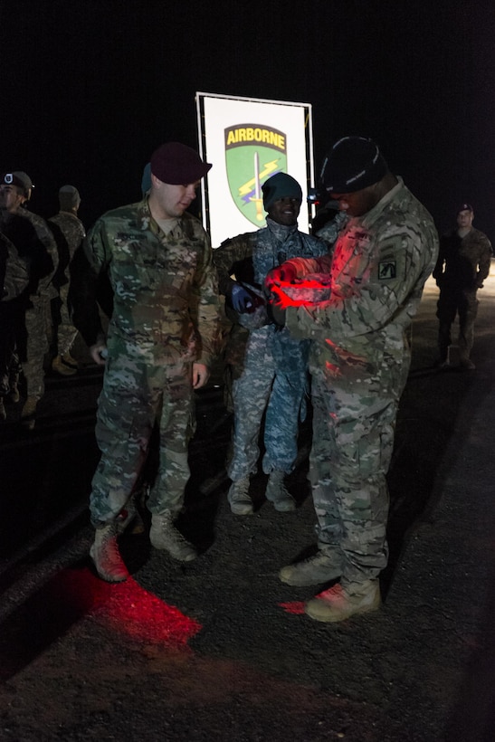 A paratrooper has his helmet inspected in the manifest area at Sicily drop zone before the Randy Oler Memorial Operation Toy Drop on Fort Bragg, N.C., Dec. 5, 2015.  U.S. Army photo by Timothy L. Hale