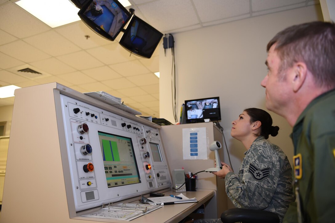 Col. Michael Richards and Staff Sgt. Maribel Cortez communicate with patients undergoing treatment in the multiplace hyperbaric chamber at the Wilford Hall Ambulatory Surgical Center, Joint Base San Antonio-Lackland, Nov. 18, 2015. Patients are closely monitored during each dive by technicians and doctors, both inside and out of the chamber, to ensure patient safety at all times. Richards is the 59th Hyperbaric Medicine Flight commander; Cortez is a hyperbaric medical technician. (U.S. Air Force photo by Tech. Sgt. Christopher Carwile)