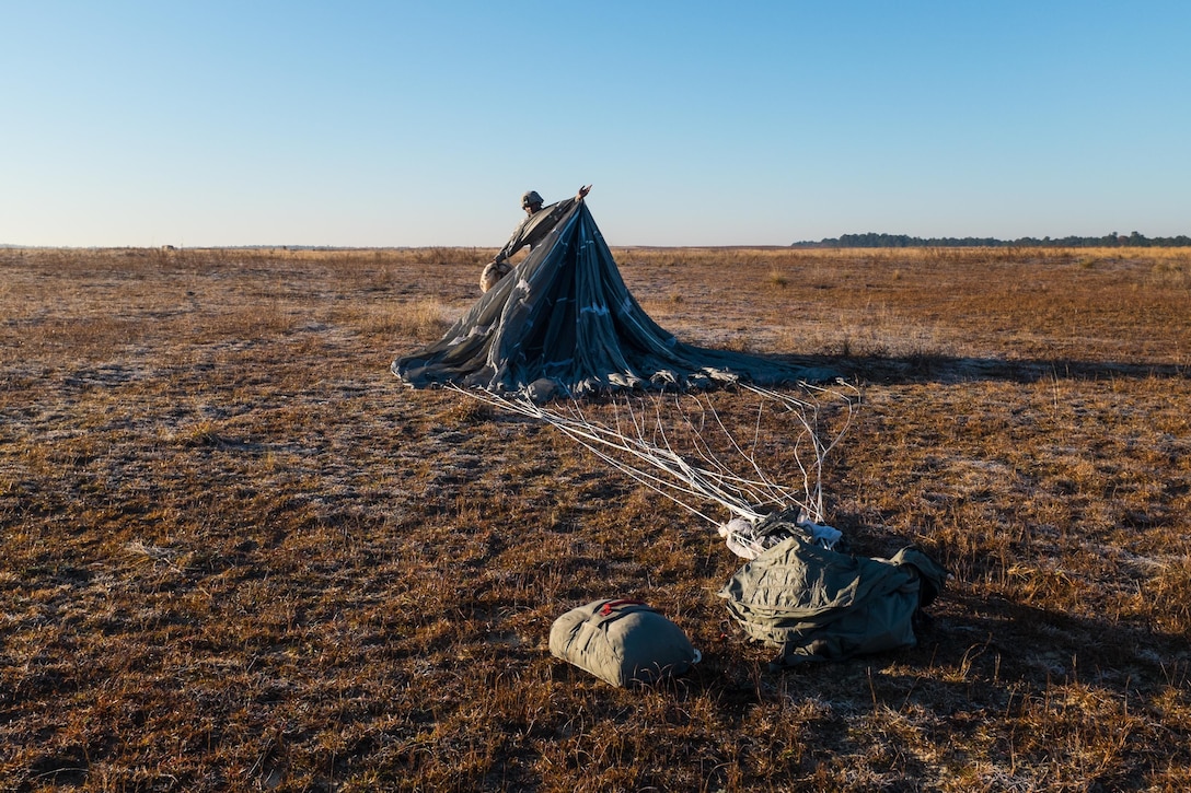 An Army paratrooper packs his parachute after a successful jump during the Randy Oler Memorial Operation Toy Drop over Sicily drop zone on Fort Bragg, N.C., Dec. 5, 2015. U.S. Army photo by Timothy L. Hale