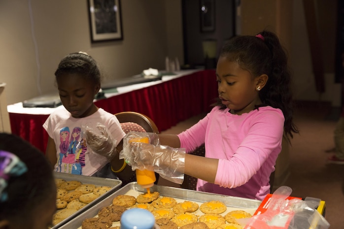 Lakahla McCoy, 8, daughter of Gunnery Sgt. Adrian McCoy, regimental supply chief, 7th Marine Regiment, decorates cookies for service members, during Treats for Troops at the Frontline Restaurant, Dec. 8, 2015. More than 2,000 cookies were decorated to be handed out to local Marines and sailors. (Official Marine Corps photo by Lance Cpl. Connor Hancock/Released)