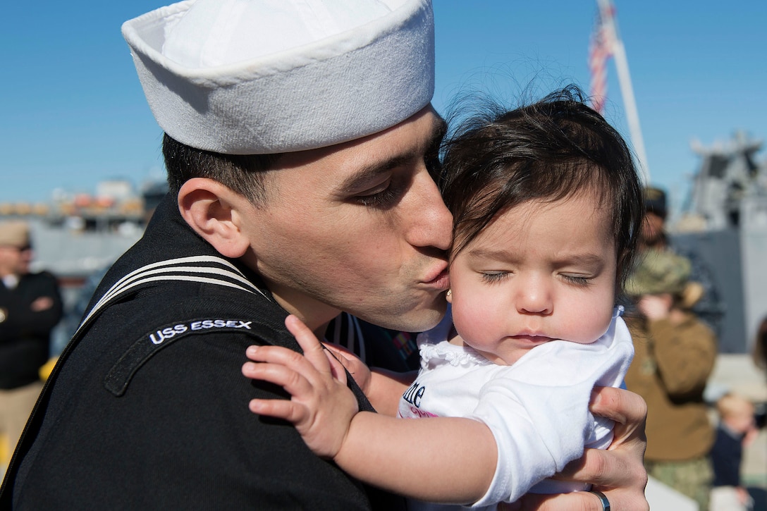 U.S. Navy Petty Officer 1st Class Ben Hernandez kisses his newborn child after returning from a seven-month deployment aboard the amphibious assault ship USS Essex in San Diego, Dec. 15, 2015. U.S. Navy photo by Petty Officer 3rd Class James Vazquez