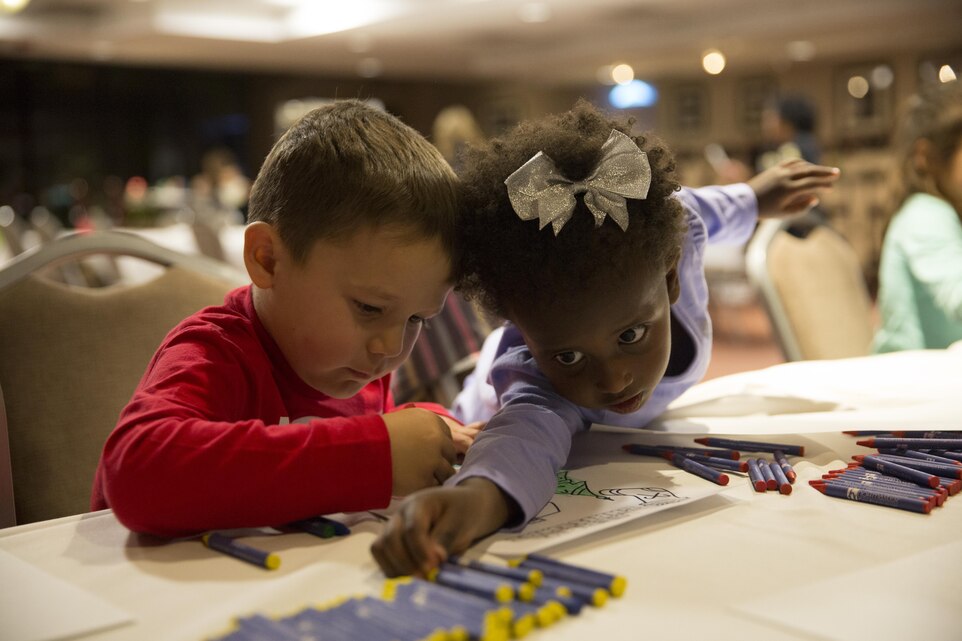 Preston Herrera, 4, son of Master Sgt. Manuel Herrera Jr., faculty advisor, Marine Corps Tactics and Operations Group, and Raija Ginder, 3, daughter of Zachary Ginder, college counselor, Base Programs Office, color Christmas artwork for service members at the Frontline Restaurant, during Treats for Troops, Dec. 8, 2015. Volunteers made approximately 50 hand-colored pieces of artwork during the event. (Official Marine Corps photo by Lance Cpl. Connor Hancock/Released)