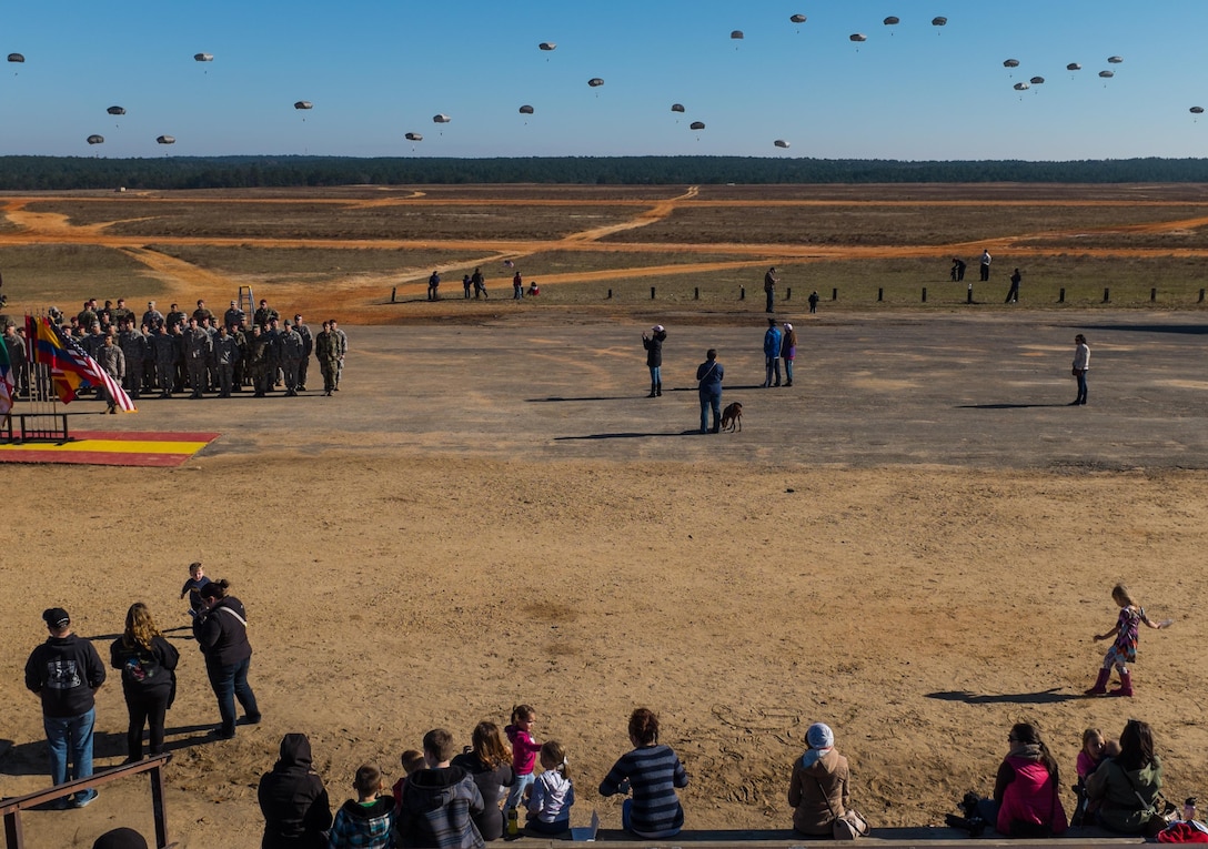 Army paratroopers fill the sky as friends and families watch during the Randy Oler Memorial Operation Toy Drop over the Sicily drop zone on Fort Bragg, N.C., Dec. 5, 2015. U.S. Army photo by Timothy L. Hale