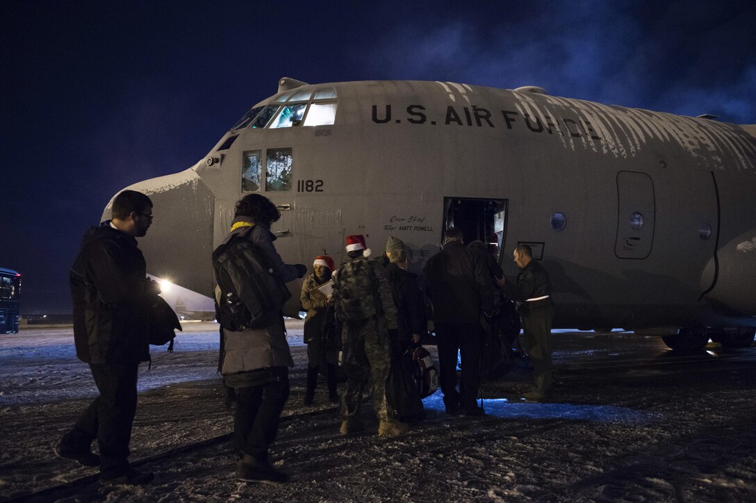 Service members and volunteers participating in Operation Santa Claus board a C-130H Hercules aircraft on Joint Base Elmendorf-Richardson, Dec. 5, 2015. The aircraft crew is assigned to the Alaska Air Force National Guard’s 144th Airlift Squadron. U.S. Air Force photo by Alejandro Pena