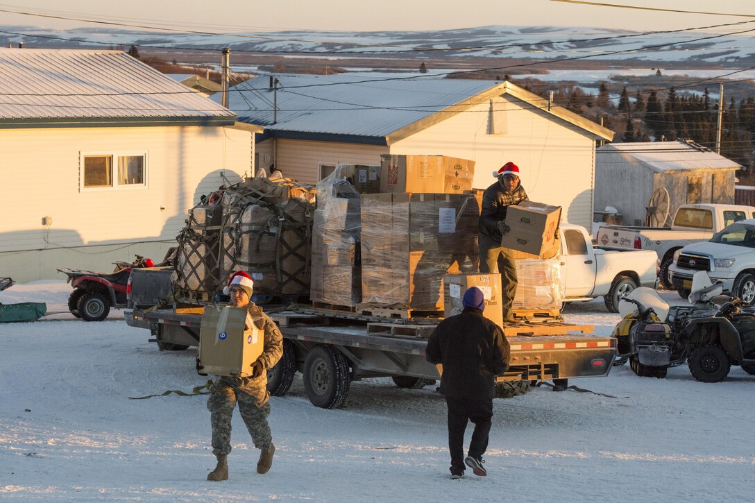 Service members, Alaska National Guardsmen and volunteers from approximately 30 groups and organizations, unload boxes of presents to bring holiday cheer to underserved children during Operation Santa Claus to the village of St. Mary's, Alaska, Dec. 5, 2015. U.S. Air Force photo by Alejandro Pena