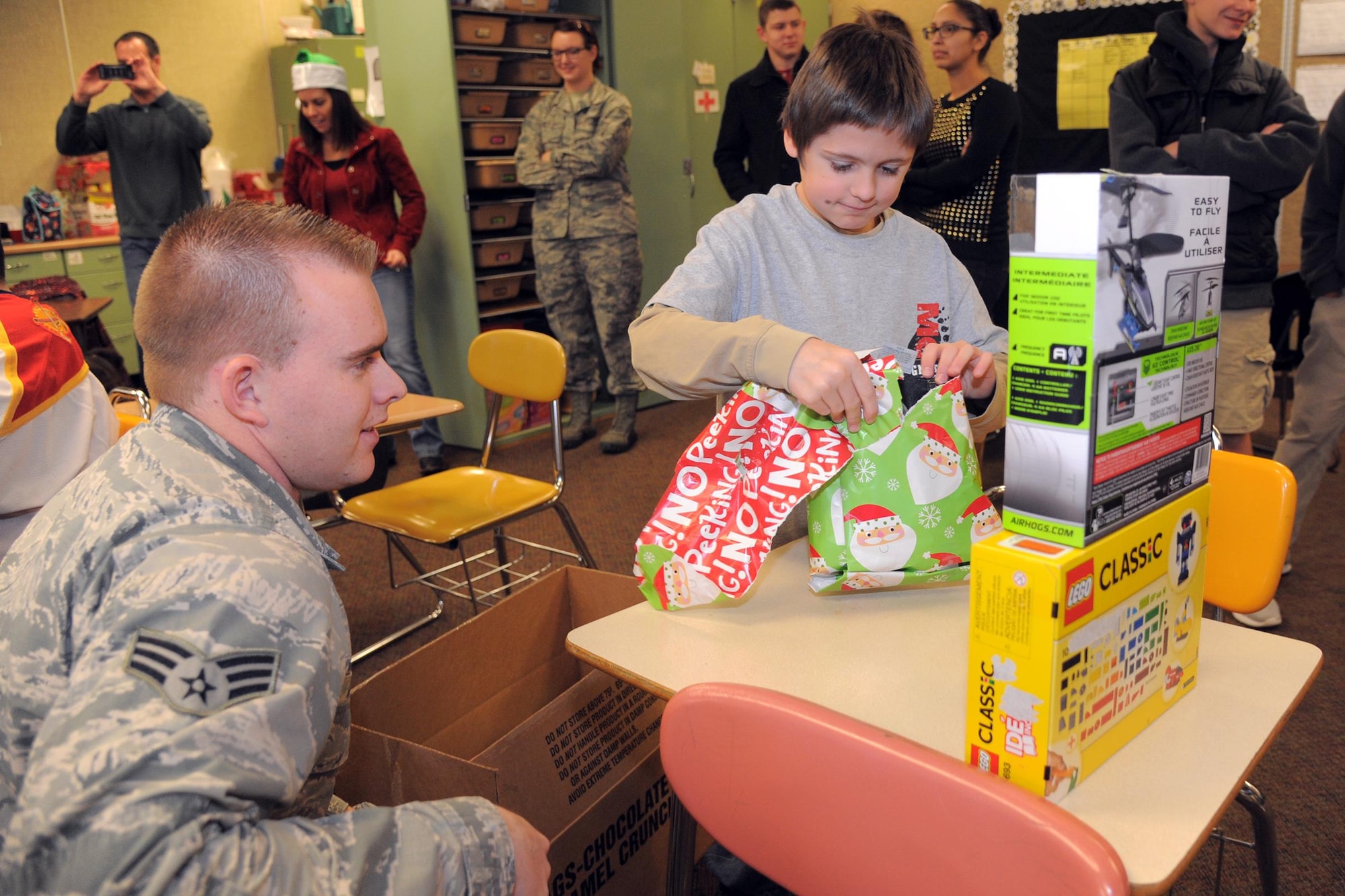 Senior Airman Jacob Canter, 419th Maintenance Group, helps a child unwrap gifts at a Christmas party for students with special needs at Ogden’s Mound Fort Junior High Dec. 16. (U.S. Air Force photo/Todd Cromar)
