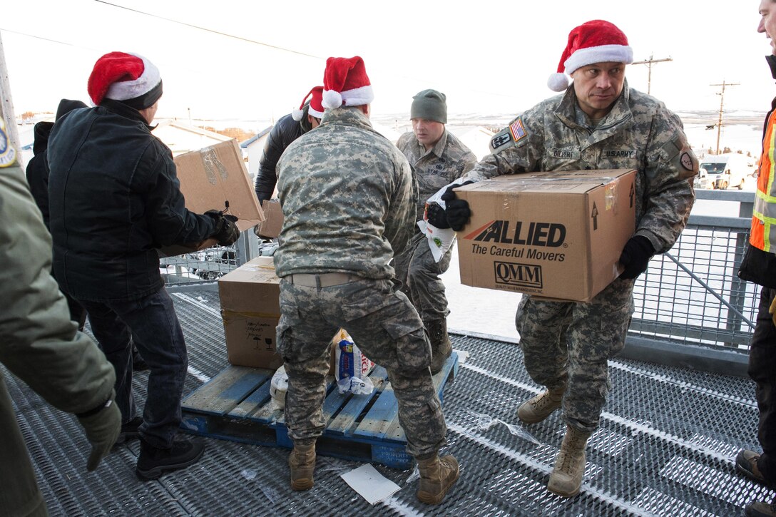 Alaska National Guardmen and other volunteers deliver boxes of donated food and presents to the residents of St. Mary's, Alaska, during Operation Santa Claus, Dec. 5, 2015. U.S. Air Force photo by Alejandro Pena