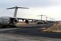 Eleven C-17 Globemaster IIIs line up on the runway at Moses Lake, Wash., after an airdrop during exercise Rainier War Dec. 10, 2015. Rainier War is a semiannual large formation exercise, hosted by the 62nd Airlift Wing, designed to train aircrews under realistic scenarios that support a full spectrum operations against modern threats and replicate today&#39;s contingency operations. (U.S. Air Force photo/Senior Airman Divine Cox)