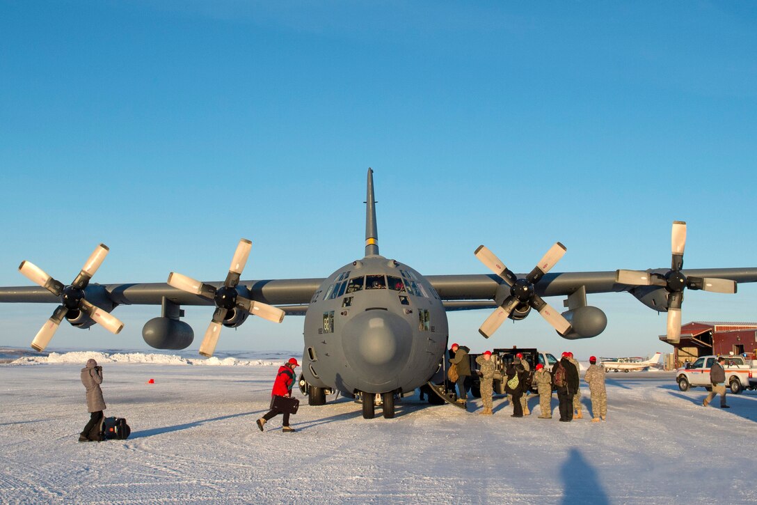 Service members and volunteers board a C-130H Hercules aircraft after completing Operation Santa Claus at St. Mary's, Alaska, Dec. 5, 2015. U.S. Air Force photo by Alejandro Pena
