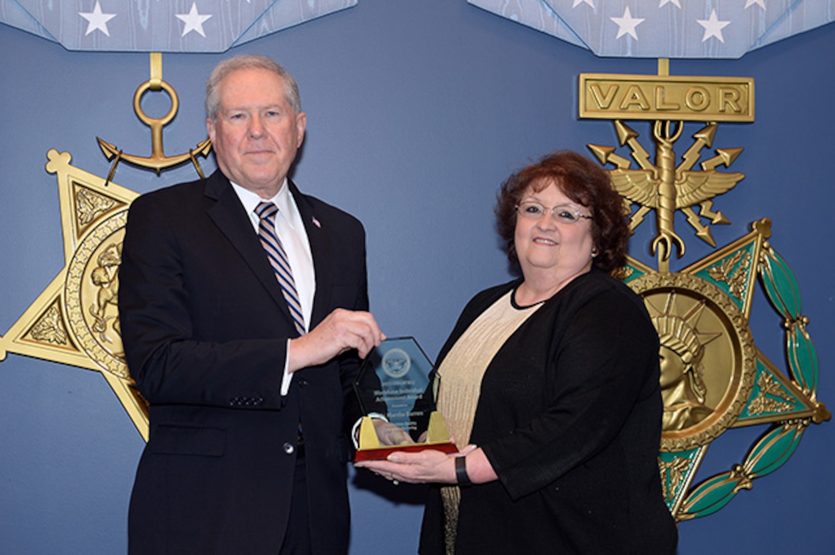 The Under Secretary of Defense for Acquisition, Technology, and Logistics, the Honorable Frank Kendall hosts the 2015 Defense Acquisition Workforce awards at the Pentagon, Arlington Va., Dec 10,2015.DLA Aviation’s Supplier Operations Directorate’s Technical Quality Supervisor Marsha Barron receives the Individual Achievement Award in Production, Quality, and Manufacturing.(U.S. Army photo by Mr. Leroy Council, AMVID/Released)