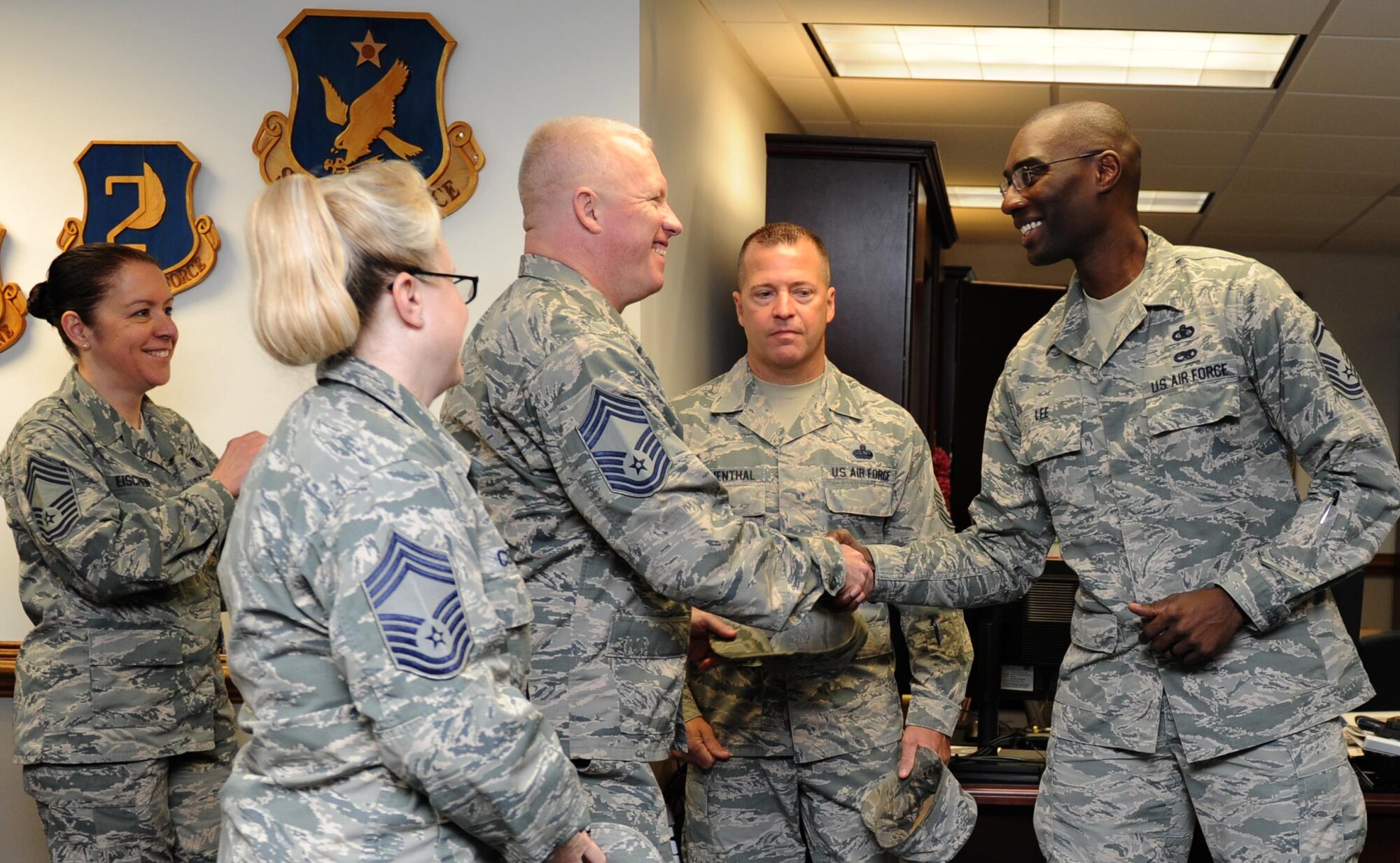 Senior Master Sgt. Hamp Lee III, 2nd Air Force executive officer, is congratulated by Chief Master Sgt. Derick Stepp, 81st Mission Support Group superintendent, and other Keesler chiefs at the 2nd AF headquarters building Dec. 17, 2015, Keesler Air Force Base, Miss. Keesler had six senior master sergeants selected for promotion to the rank of chief master sergeant. (U.S. Air Force photo by Kemberly Groue)