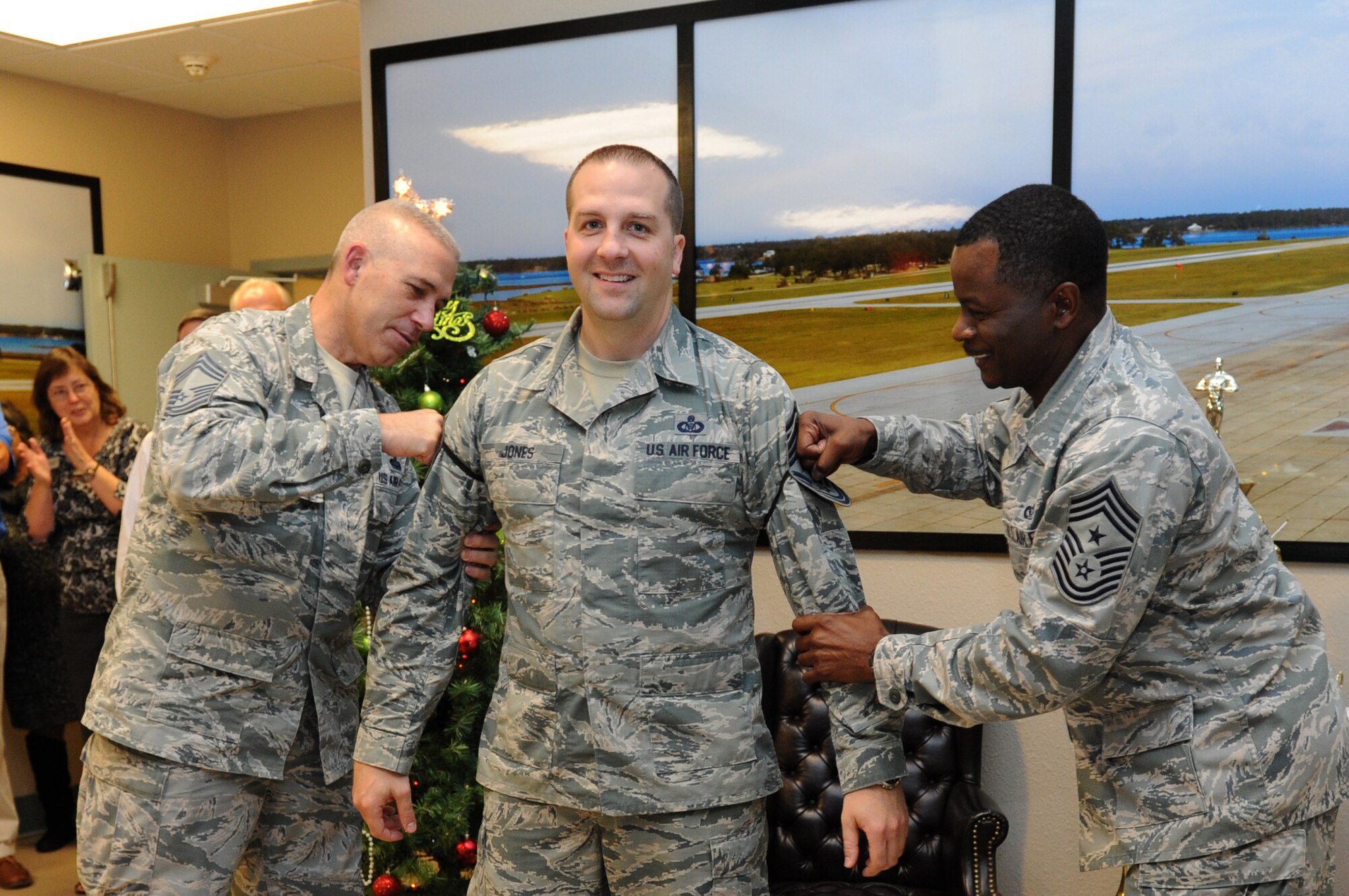 Senior Master Sgt. Shawn Jones, 334th Training Squadron aviation resource management technical training superintendent, is congratulated with a ceremonial promotion pinning on by Chief Master Sgts. Robert Winters, 81st Training Group superintendent, and Harry Hutchinson, 81st Training Wing command chief, at Cody Hall Dec. 17, 2015, Keesler Air Force Base, Miss. Keesler had six senior master sergeants selected for promotion to the rank of chief master sergeant. (U.S. Air Force photo by Kemberly Groue)