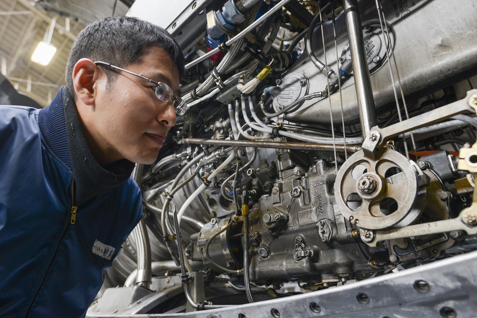 Japan Maritime Self-Defense Force Petty Officer 2nd Class Takeshi Murai, 4 Maintenance Squadron, inspects a C-130 Hercules engine during a facility tour at Yokota Air Base, Japan, Dec. 11, 2015. The JMSDF maintainers compared the maintenance conducted at Yokota to their own to help improve processes and efficiency. (U.S. Air Force photo by Staff Sgt. Cody H. Ramirez/Released)