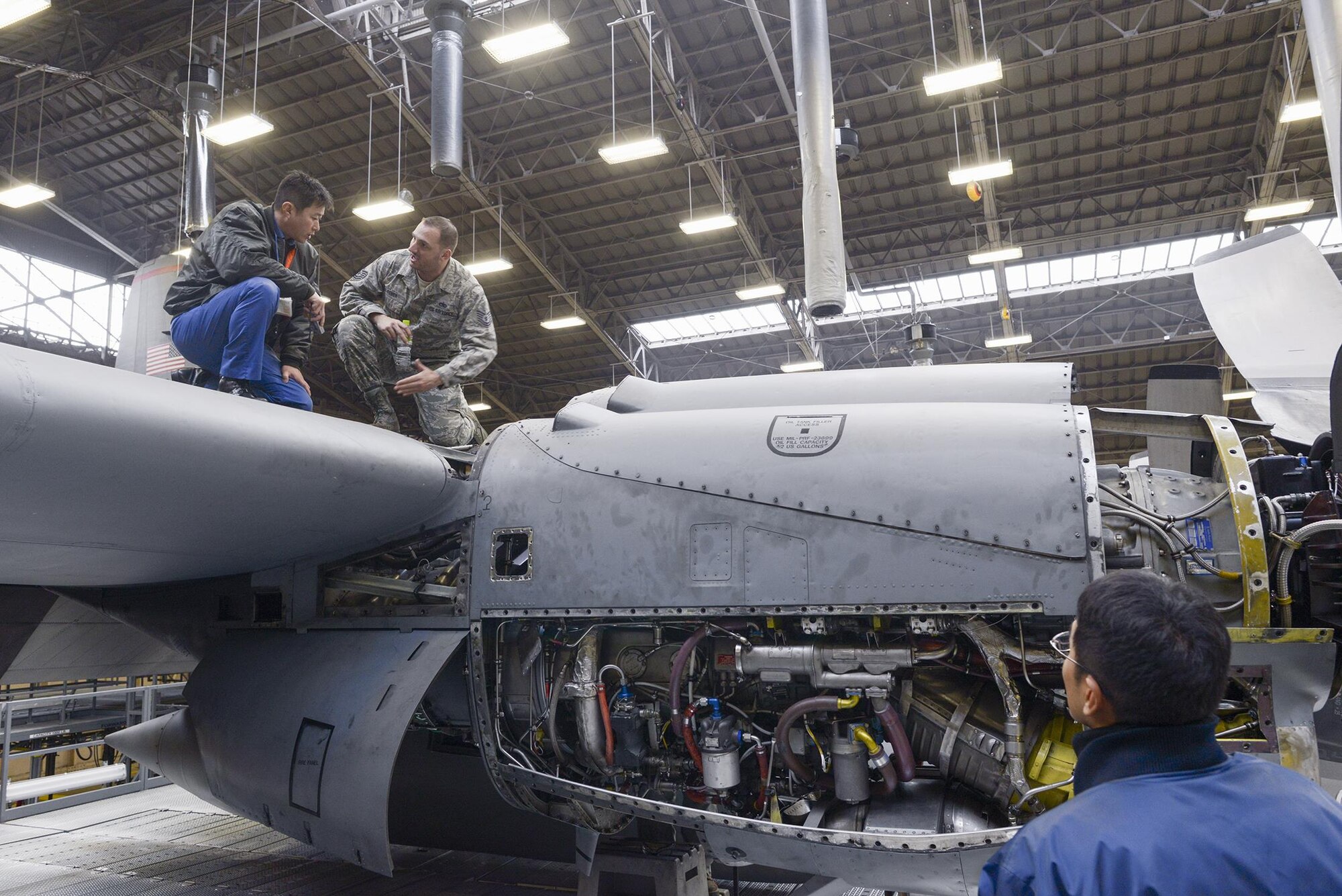 Tech. Sgt. Jeff De Remer, 374th Maintenance Squadron repair and reclamation section chief, explains specifics regarding Yokota's C-130 Hercules maintenance to members of the Japan Maritime Self-Defense Force at Yokota Air Base, Japan, Dec. 11, 2015. Members with the 374th Maintenance Group discussed maintenance with the JSMDF members and gave them tours of multiple facilities at Yokota. (U.S. Air Force photo by Staff Sgt. Cody H. Ramirez/Released)