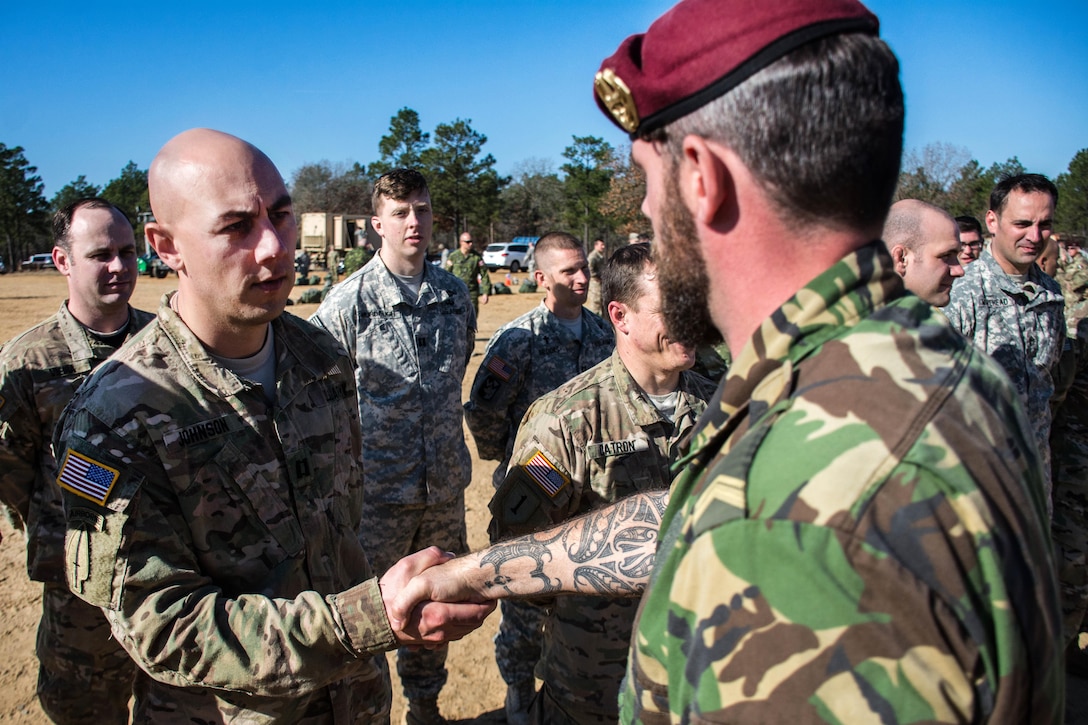 U.S. Army Capt. Travis Johnson, left, receives Dutch jump wings from Dutch Sgt. 1st Class Niels Van Gestel during Operation Toy Drop at Luzon drop zone on Fort Bragg, N.C., Dec. 8, 2015. Johnson is assigned to the 1st Battalion, 8th Group. U.S. Army photo by Pfc. Darion Gibson