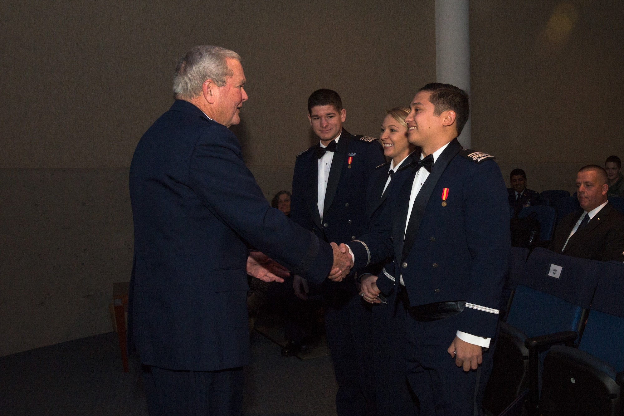 Retired Brig. Gen. Robert Giffen, representing the Class of 1965, presented second lieutenant rank to 2nd Lts. Mark Suges, Lindsay Ebel, and Joshua Burdge Dec. 16 at the Air Force Academy's fall graduation and commissioning ceremony. (U.S. Air Force photo by Liz Copan)

