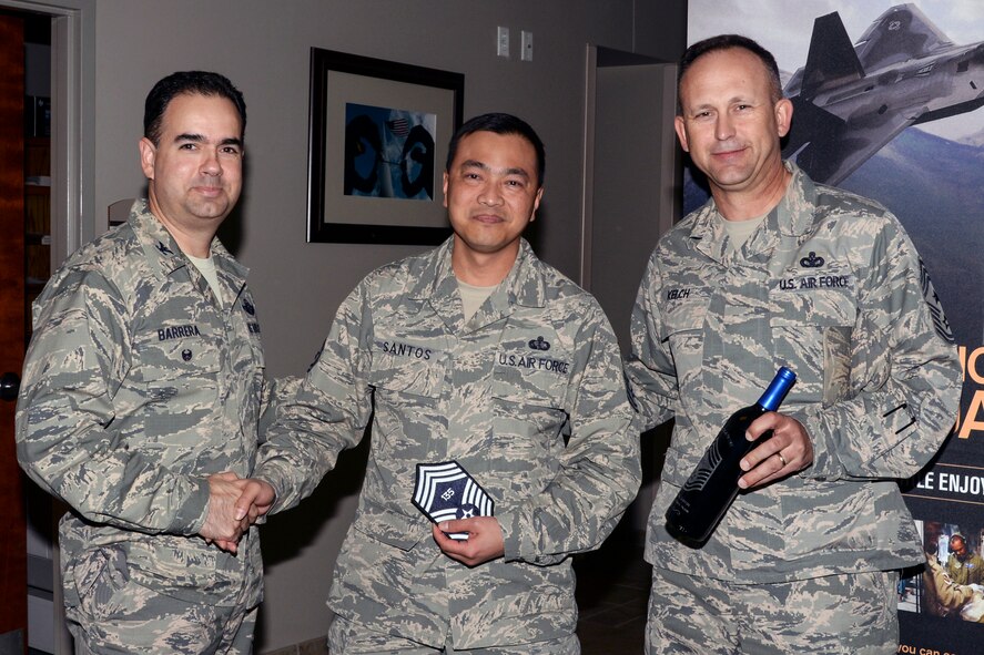 U.S. Air Force Col. Mark Barrera, (left), 23d Wing vice commander, Senior Master Sgt. Adonis Santos, (middle), 23d Force Support Squadron sustainment services flight superintendent, and Chief Master Sgt. David Kelch, 23d Wing command chief, pose for a photo after receiving notification that Santos was selected for chief master sergeant, Dec. 17, 2015, at Moody Air Force Base, Ga. Santos was selected to promote to the rank of chief master sergeant and will become a part of the one percent that will ever make the rank. (U.S. Air Force photo by Airman 1st Class Janiqua P. Robinson/Released)