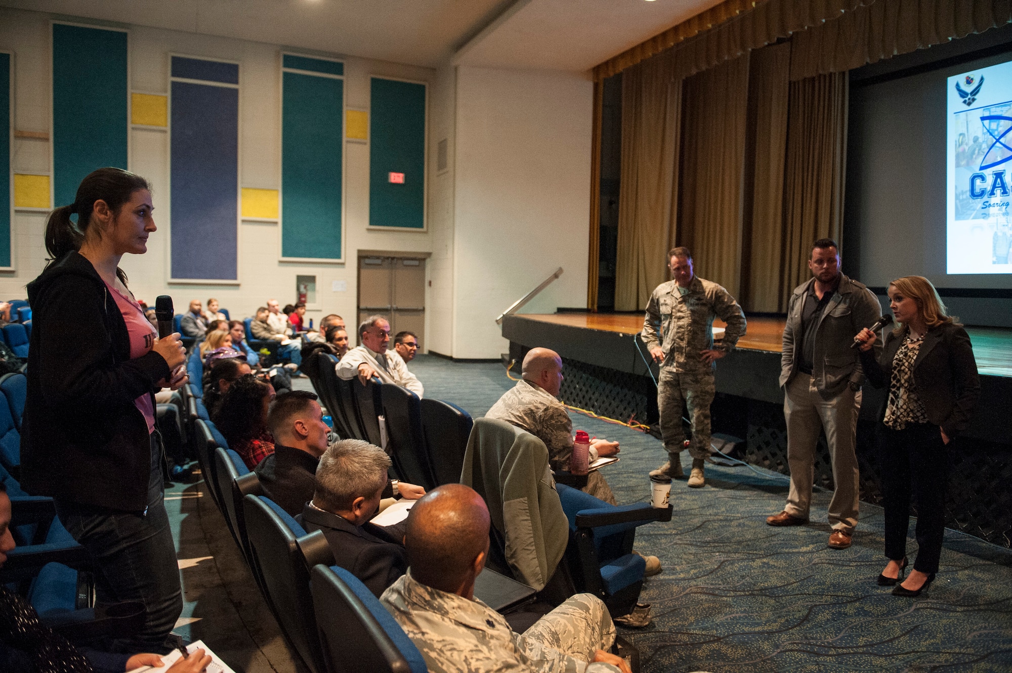 A representative from Coral Academy of Science Las Vegas answers a question from a participant in the public charter school town hall meeting at Nellis Air Force Base, Nev., Dec. 15, 2015. Boutwell and the CASLV reps provided approximately 200 audience members information and answers to pressing questions. (U.S Air Force photo by Staff Sgt. Siuta B. Ika)