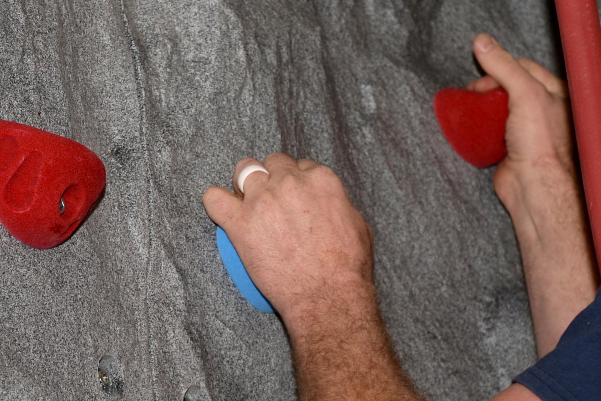 Alan McEvoy tests the durability of the newly installed rock wall, Dec. 16, 2015, at Seymour Johnson Air Force Base, North Carolina. The rock wall has an automatic belay system, so each climber can lock themselves in and, using the counter-weight, safely climb the wall. (U.S. Air Force photo/Airman 1st Class Ashley Williamson)