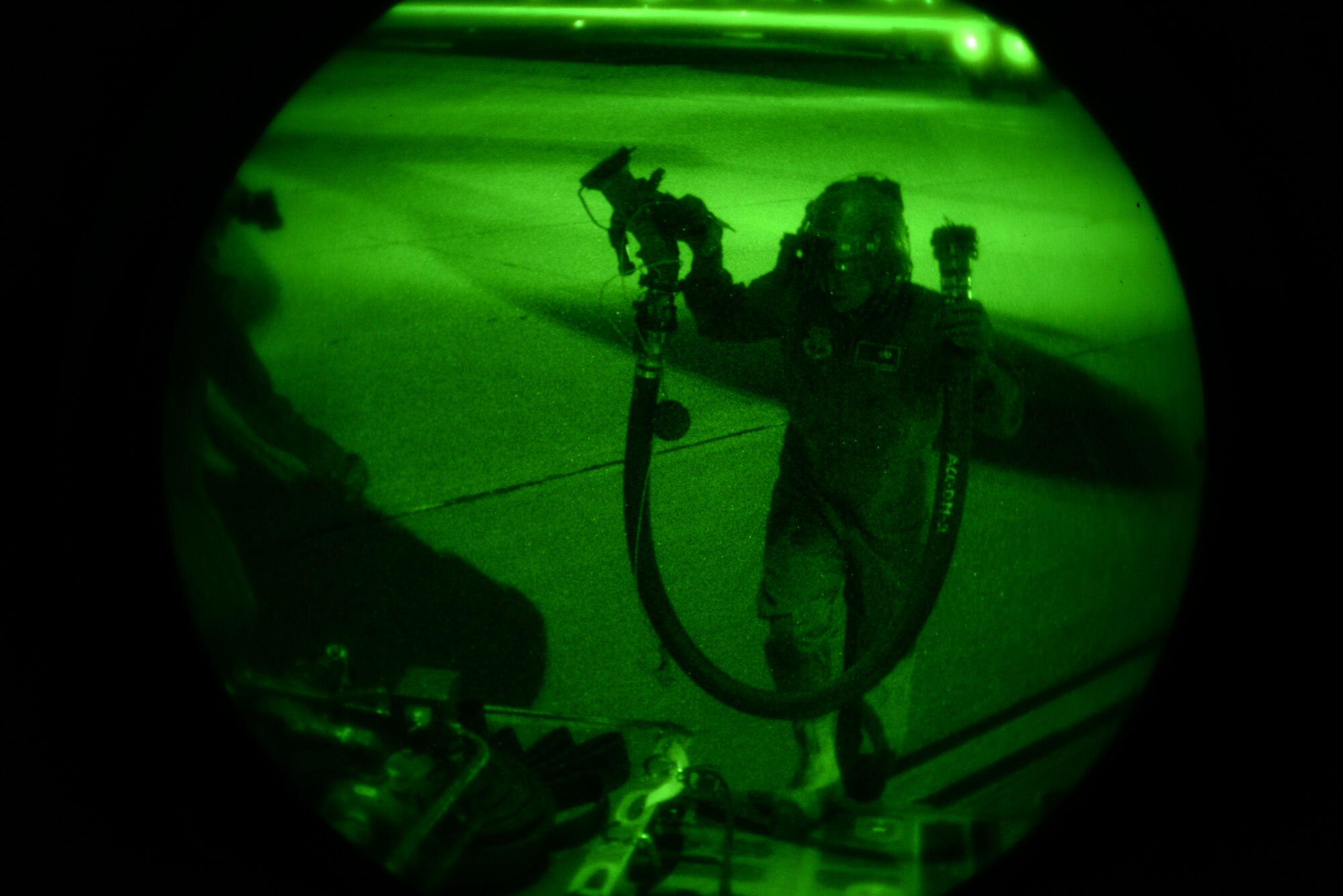 A U.S. Air Force 563rd Operations Support Squadron forward area refueling point team member carries a disconnected defuel pump from a 79th Rescue Squadron HC-130J Combat King II at Davis-Monthan Air Force Base, Ariz., Dec. 9, 2015. The training was composed by the 563rd OSS and the 79th RQS. (U.S. Air Force photo by Airman 1st Class Mya M. Crosby/Released)