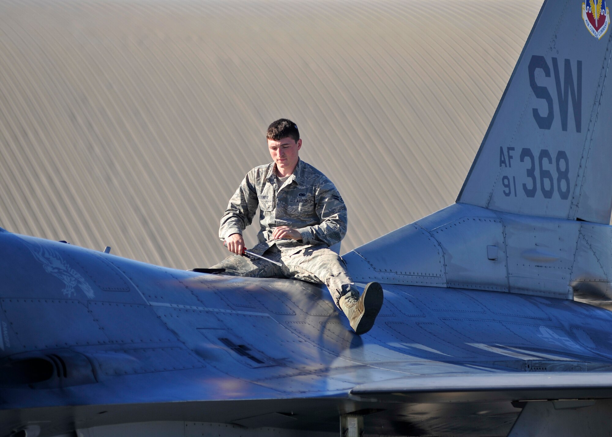 A 77th Aircraft Maintenance Unit dedicated crew chief from Shaw Air Force Base, S.C. sits on an F-16 Fighting Falcon Dec. 15 at the Tyndall AFB, Fla., flightline during the Checkered Flag 16-1 exercise. Checkered Flag 16-1 is a large-force exercise that simulates employment of a large number of aircraft from a simulated deployed environment. (U.S. Air Force photo by Senior Airman Sergio A. Gamboa/Released) 
