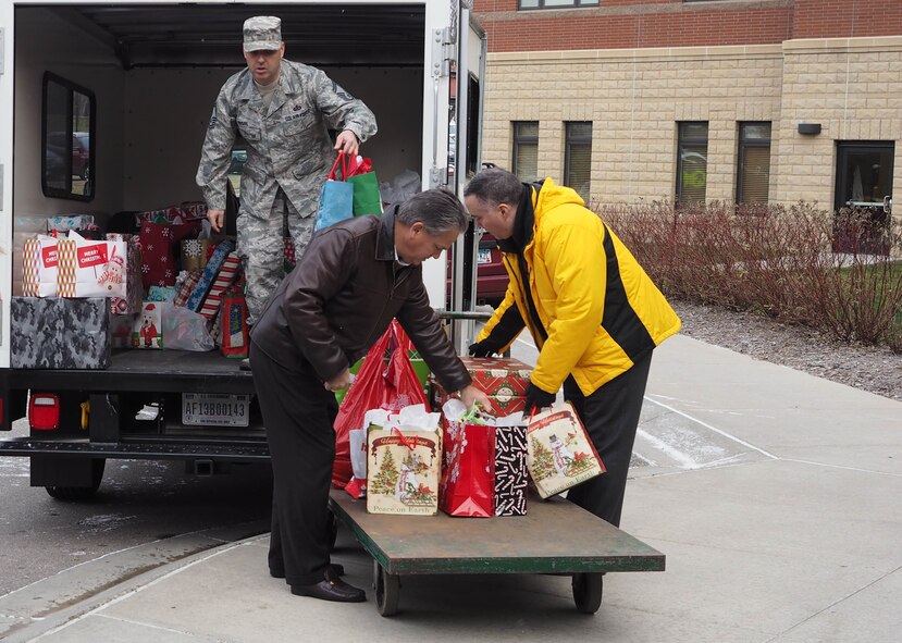Senior Master Sgt. Andy Regal, Pete Mangone (left) and Mike Auel unload gifts at the Minnesota Veterans Home Dec. 17. (Air Force Photo/Paul Zadach)

