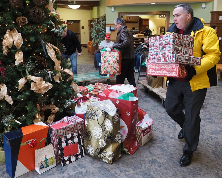 Mike Auel, 934th Airlift Wing comptroller, places gifts under the tree at the Minnesota Veterans Home Dec. 17. (Air Force Photo/Paul Zadach)

