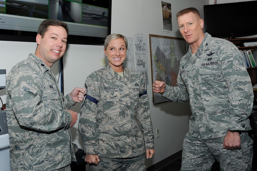 Col. Michael Grismer, 436th Airlift Wing commander, right, and Lt. Col. Jonathan Diaz, 436th AW director of staff, left, congratulate Senior Master Sgt. Rebecca Thomas, 436th AW Command Post superintendent, of her selection for promotion to the rank of chief master sergeant Dec. 17, 2015, at Dover Air Force Base, Del. Team Dover had four senior master sergeants selected for promotion. (U.S. Air Force photo/Greg L. Davis)