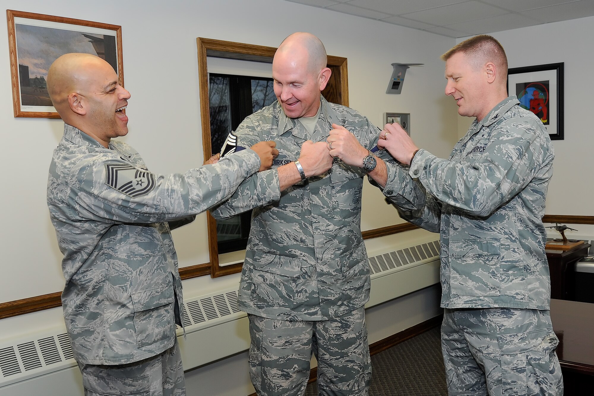 Col. Michael Grismer, 436th Airlift Wing commander, right, and Chief Master Sgt. Gerald Moore, 436th AW (acting) command chief, left, congratulate Senior Master Sgt. Steven Dirksen, 436th Operations Support Squadron superintendent, on his selection for promotion to the rank of chief master sergeant Dec. 17, 2015, at Dover Air Force Base, Del. Team Dover had four senior master sergeants selected for promotion. (U.S. Air Force photo/Greg L. Davis)