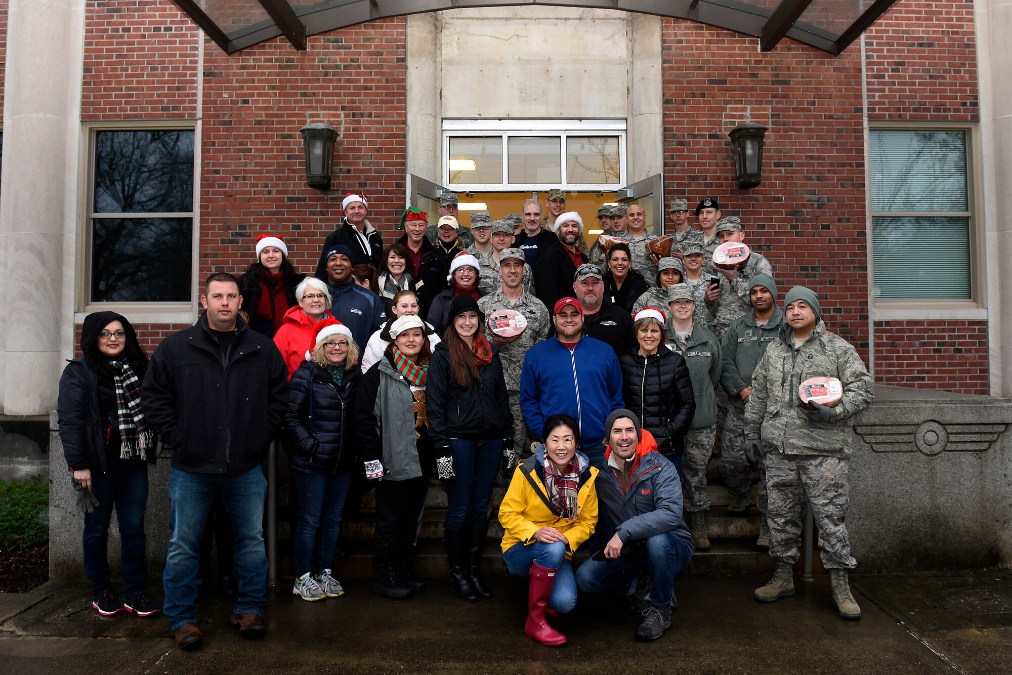 Local community leaders and 62nd Airlift Wing leadership pose for a group photo with holiday hams Dec. 17, 2015 at Joint Base Lewis-McChord. This is the second time in the last two months that the community partners have donated to JBLM servicemembers. They also delivered turkeys for Thanksgiving in Novembers. (U.S. Air Force photo/Tech. Sgt. Tim Chacon)