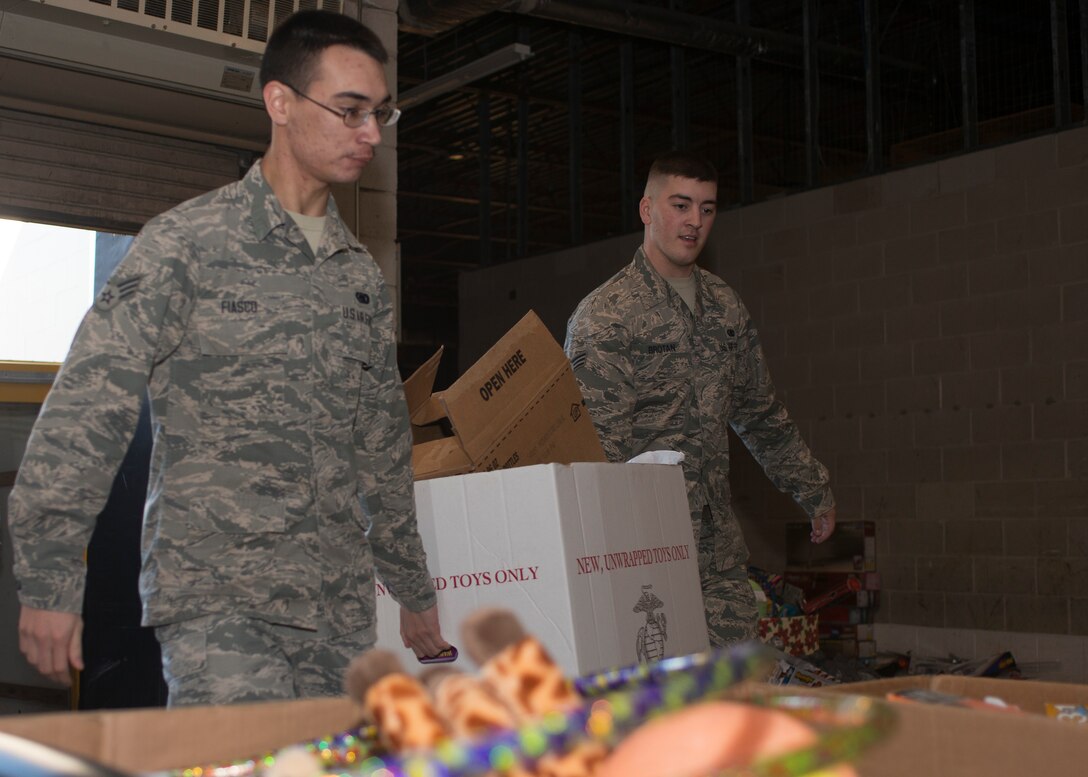 U.S. Air Force Senior Airmen Joseph Brotan and William Fiasco, Mission Capable (MICAP) technicians assigned to the 438th Supply Chain Operations Squadron (SCOS), carry toys while volunteering at the Salvation Army at Newport News, Va., Dec. 10, 2015. The 438th SCOS F-16 Fighting Falcon MICAP section efforts led to 1,900 local families receiving toys this holiday season. (U.S. Air Force photo by Staff Sgt. J.D. Strong II)