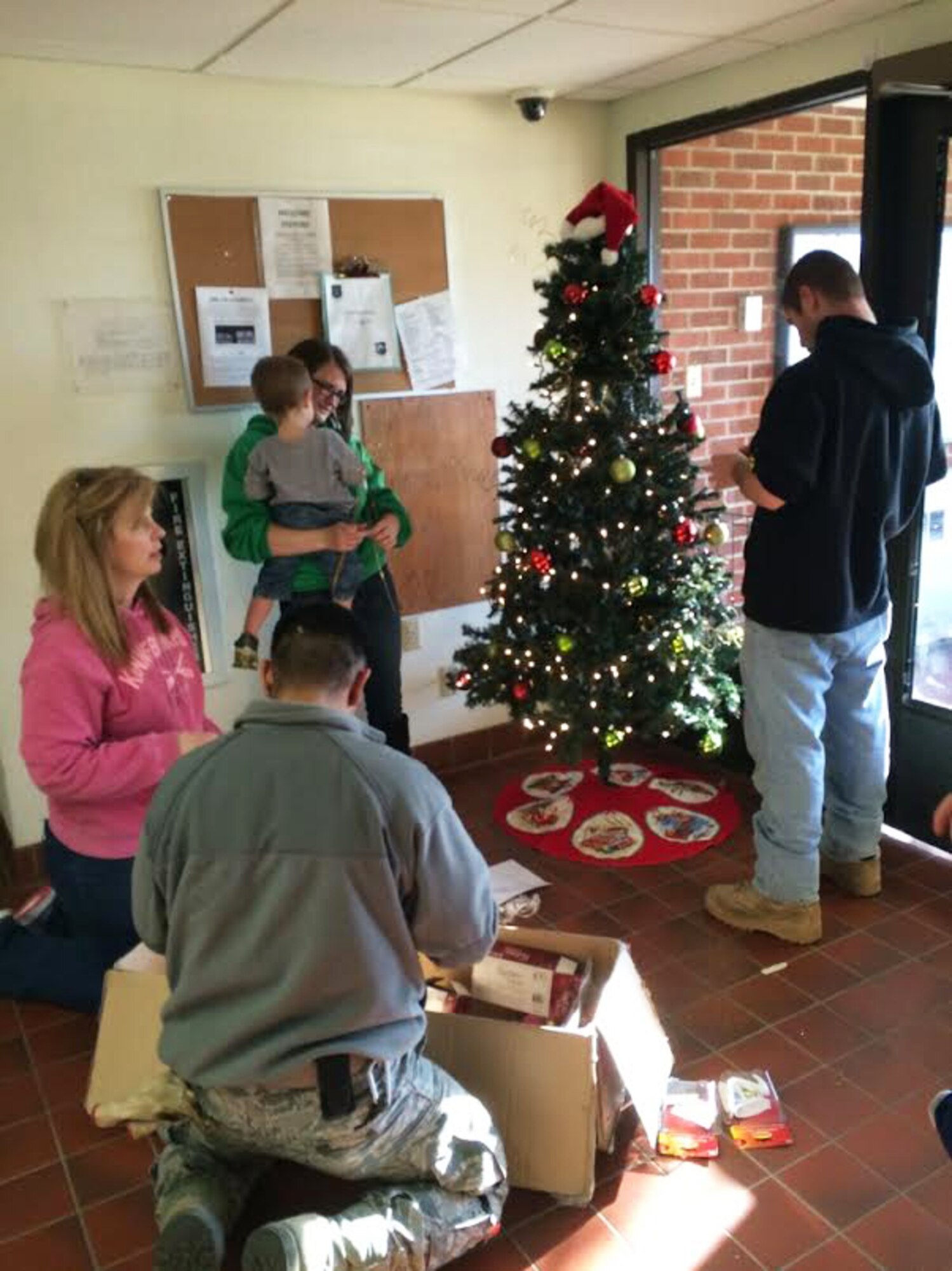 Led by the Key Spouses Group, Airmen and families decorate Christmas trees at Minot Air Force Base, N.D., Dec. 3, 2015. The volunteers decorated all the dorms with Christmas trees and garland to help spread holiday cheer. (Courtesy photo)