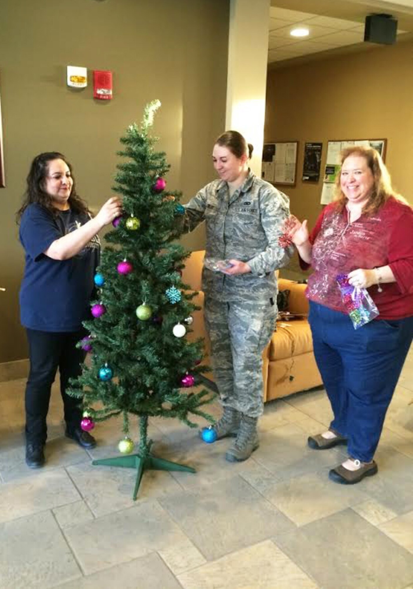 Led by the Key Spouses Group, Airmen and families decorate Christmas trees at Minot Air Force Base, N.D., Dec. 3, 2015. The volunteers decorated all the dorms with Christmas trees and garland to help spread holiday cheer. (Courtesy photo)